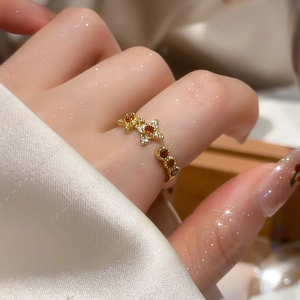 Detailed macro view of 18k gold flower star ring with red crystals on a silk background