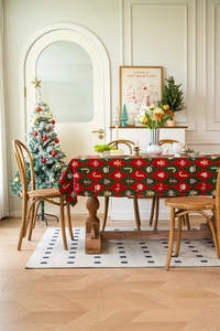 Detail of red and green festive Christmas tablecloth with Santa and gingerbread motifs