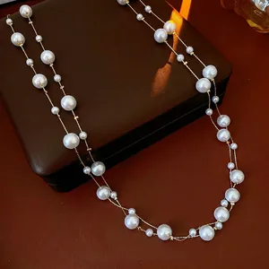 French vintage long pearl necklace with golden chain on a premium leather jewelry box