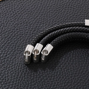 Detail of magnetic buckles on black braided leather punk bracelet with metallic finish