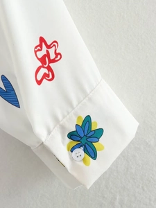 Vue détaillée du poignet de chemise avec imprimés graffiti colorés et détails du bouton