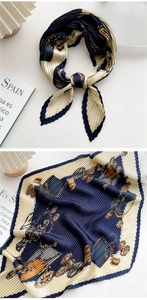 Detail of pleated silk scarf with navy blue and cream carriage pattern print