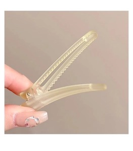Close-up of matte beige plastic hair clip featuring a secure serrated teeth design