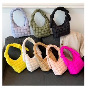 Eight colors of quilted puffer cloud bags with stylish knotted straps on a sofa