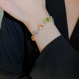 Vue détaillée des cristaux colorés et diamants micro-pavé sur le bracelet en or