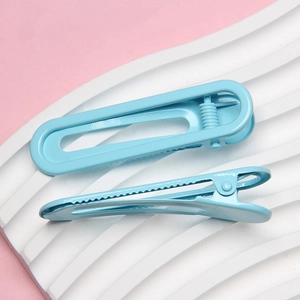 Pair of light blue 6cm U-shaped lacquered metal hair clips on a wavy white stand