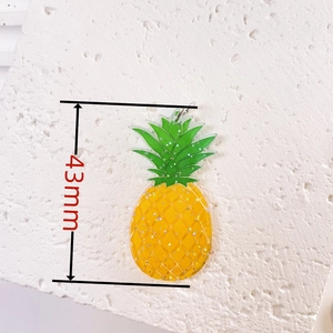 Macro detail of 43mm acrylic pineapple charm with yellow glitter and green leaves