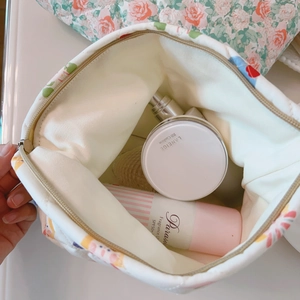 Top view of floral quilted makeup bag showing internal storage for cosmetics and skincare