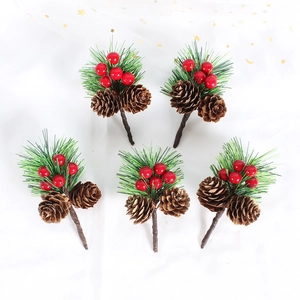 Flat lay of artificial pine needles with red berries and natural pine cones for Christmas