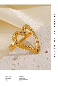 Detailed view of golden heart ring with irregular hammered texture on silk fabric