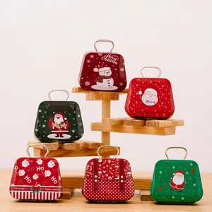 Christmas tin suitcase gift boxes with Santa designs displayed on a wooden stand