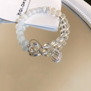 Detailed shot of bowknot beaded bracelet with moon pendant on a mirror background