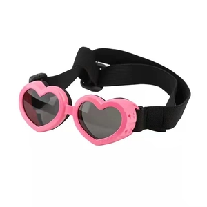 Pink heart-shaped dog sunglasses with adjustable black elastic strap on white background