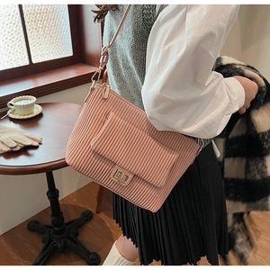 Detail of pink corduroy shoulder bag showing fabric texture and gold metal turn-lock