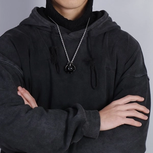 Close-up of a dragon claw pendant holding a black bead on a silver twisted chain