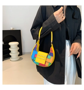 Detail of color-block mosaic pattern shoulder bag with a yellow leather flap and strap