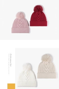 Detail of cable knit pattern and fluffy pompom on thick winter beanies in various colors