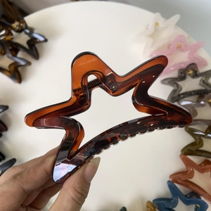 Detail of star-shaped hollow hair claw clips in various translucent colors and amber brown