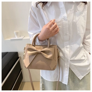 Detail of beige bow-knot crossbody bag made of faux leather with long strap for women