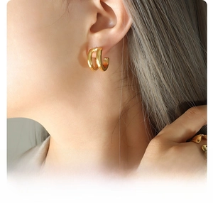 Close-up of 18K gold plated titanium steel double-hoop C-shaped earrings worn by a model