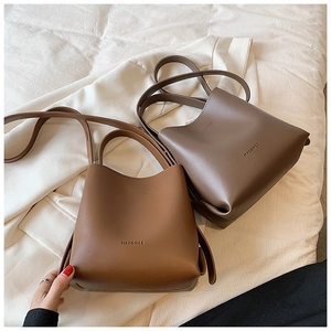 Detailed macro view of two minimalist leather tote bags in brown and taupe colors