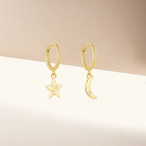 Detailed view of asymmetric S925 silver star and moon earrings with gold finish and gems