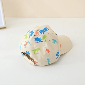 Detail of kids baseball cap featuring colorful dinosaur prints on beige cotton fabric