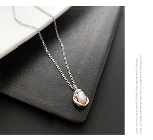 Detail of drop-shaped pendant with freshwater pearl on a delicate silver steel chain