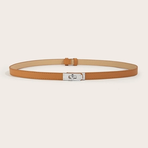 Detail of tan Saffiano leather skinny belt featuring a silver metal turn-lock buckle