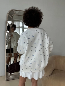 Women's white long sleeve sweater with blue floral pattern and loose casual crewneck style