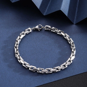 Macro shot of silver stainless steel Cuban chain bracelet on dark textured background