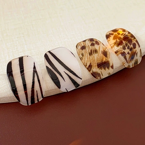 Detail view of square animal print resin rings in zebra and leopard patterns
