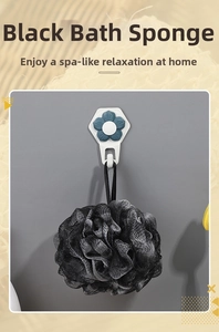 Detail of a black bamboo charcoal bath loofah mesh with a floral adhesive wall hook
