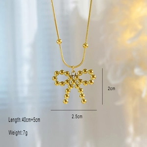 Macro shot of 18K gold plated bowknot pendant showing beaded detail and dimensions