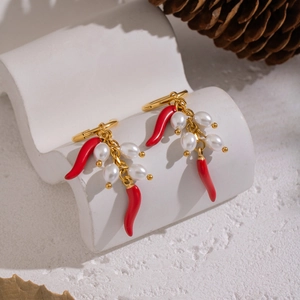 Gold chili pepper earrings with natural freshwater pearls on a white wave stand