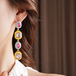 Detail of luxury vintage gold earring with pink gemstones on model