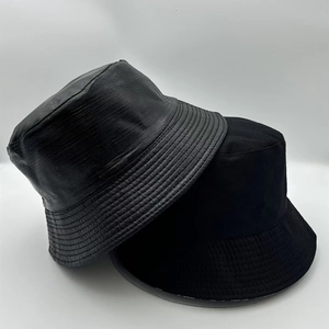 Close-up of black bucket hats showing smooth canvas and textured leather-like materials