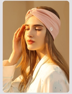 Close-up of a soft pink cotton maternity headband worn by a woman for sleep and hair care