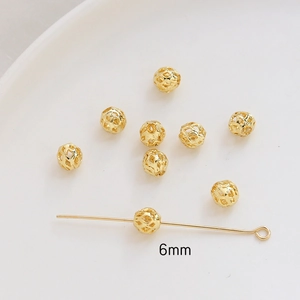 Detailed macro view of 6mm gold hollow spacer beads with intricate floral patterns for DIY