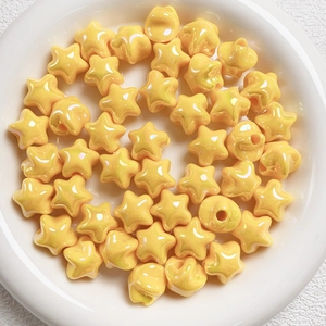 Macro shot of glossy yellow star-shaped beads in a white bowl for DIY jewelry making