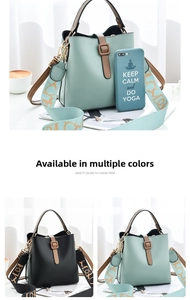 Detail of mint green and black crossbody bucket bags with wide patterned straps