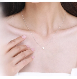 Detail shot of a minimalist 925 silver star pendant necklace worn on the collarbone