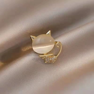 Elegant cat brooch featuring an opal stone and sparkling rhinestones on a gold setting