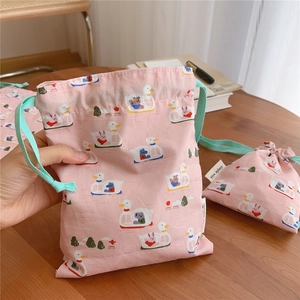 Detail of pink cotton drawstring pouches with cute duck prints and simple wish label