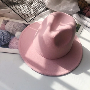 Close-up of pink wool fedora hat with wide brim on artistic decorative background