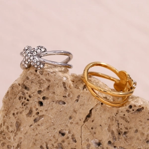 Detail von 18K Gold und Silber X-Ringen mit Micro-Pave-Kristallen auf Steinplatte