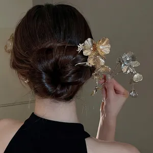 Elegant floral hair pin with sparkling crystals in gold and silver finish on model