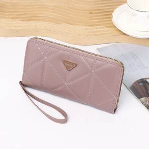 Detailed close-up of pink long wallet with geometric stitching and gold logo plaque