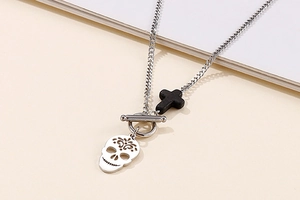 Detail of stainless steel necklace featuring skull and cross pendants with OT buckle