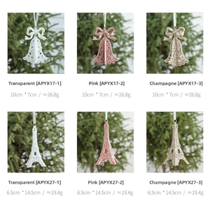 Detailed view of Christmas glitter ornaments featuring pink and gold bows and Eiffel Tower charms